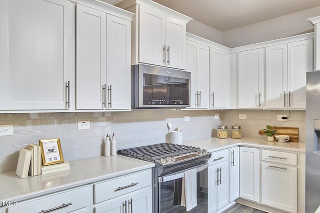 1004 Citadel Ave, Durham, NC 27713 - kitchen featuring appliances with stainless steel finishes, white cabinetry, decorative backsplash, and light stone counters