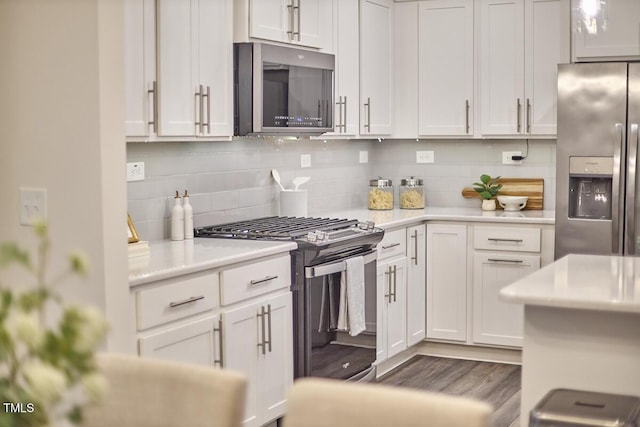 1004 Citadel Ave, Durham, NC 27713 - kitchen featuring appliances with stainless steel finishes, light countertops, backsplash, white cabinets, and wood finished floors