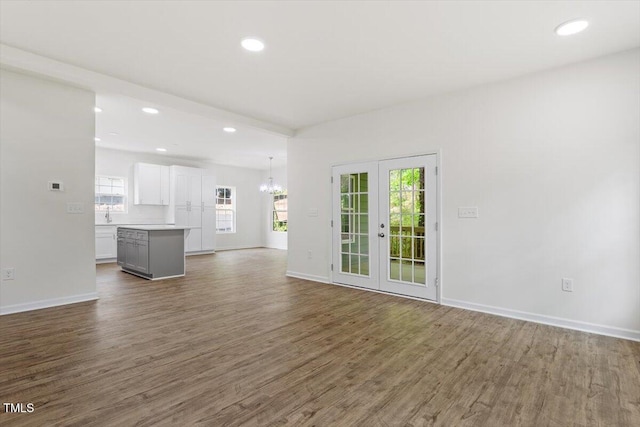 1408 S St, Durham, NC 27707 - unfurnished living room featuring wood finished floors, plenty of natural light, a chandelier, and recessed lighting