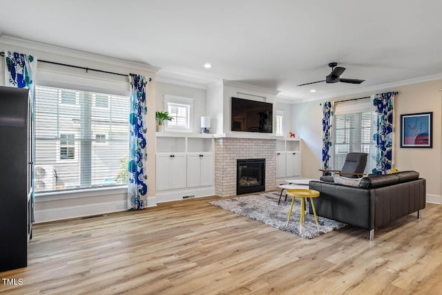 309 N Mason St, Apex, NC 27502 - living room featuring crown molding, light wood-type flooring, a ceiling fan, a brick fireplace, and recessed lighting