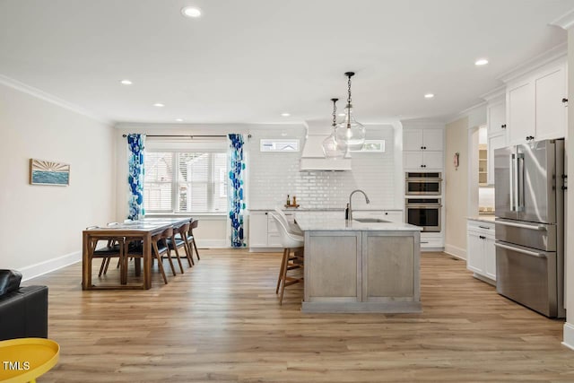 309 N Mason St, Apex, NC 27502 - kitchen with appliances with stainless steel finishes, custom range hood, decorative backsplash, light wood-style flooring, and crown molding