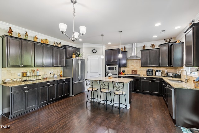90 E Calvert Ct, Clayton, NC 27527 - kitchen with appliances with stainless steel finishes, wall chimney exhaust hood, light stone counters, a center island, and backsplash