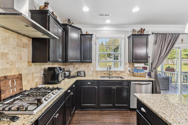 90 E Calvert Ct, Clayton, NC 27527 - kitchen featuring appliances with stainless steel finishes, wall chimney range hood, ornamental molding, dark wood-style flooring, and light stone countertops