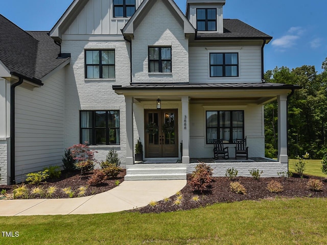 3666 Jordan Estates Way, New Hill, NC 27562 - view of front of home with covered porch, a standing seam roof, board and batten siding, a metal roof, and a front lawn