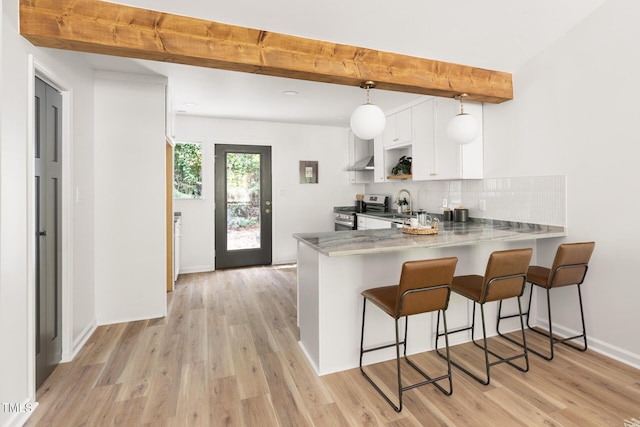 110 Mossbark Ln, Chapel Hill, NC 27514 - kitchen featuring stainless steel electric range, white cabinets, light wood-style floors, wall chimney exhaust hood, and a kitchen breakfast bar