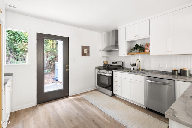 110 Mossbark Ln, Chapel Hill, NC 27514 - kitchen featuring appliances with stainless steel finishes, wall chimney exhaust hood, light wood-style floors, backsplash, and white cabinets