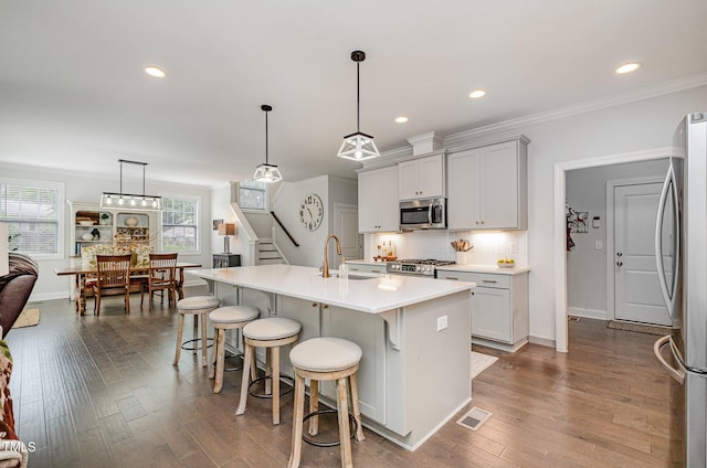 3082 Cascade Dr, Burlington, NC 27217 - kitchen featuring stainless steel appliances, a breakfast bar, wood finished floors, backsplash, and light countertops