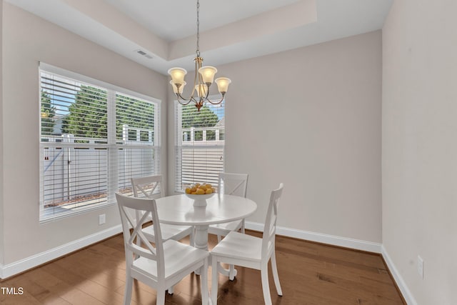 936 Blue Bird Ln, Wake Forest, NC 27587 - dining room featuring wood finished floors, a raised ceiling, and a chandelier