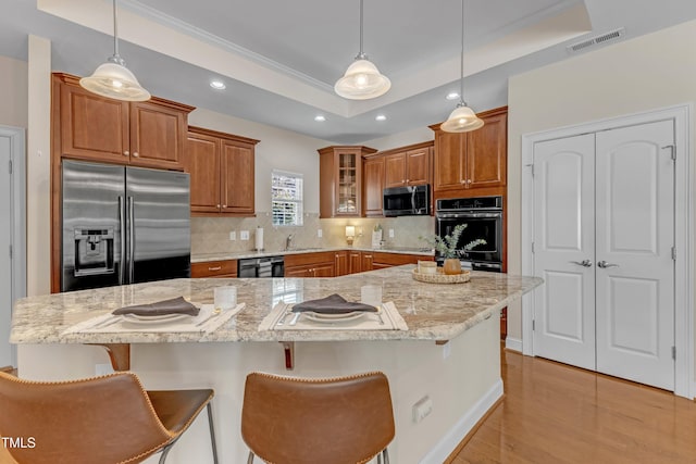936 Blue Bird Ln, Wake Forest, NC 27587 - kitchen featuring stainless steel appliances, a raised ceiling, brown cabinets, recessed lighting, and backsplash