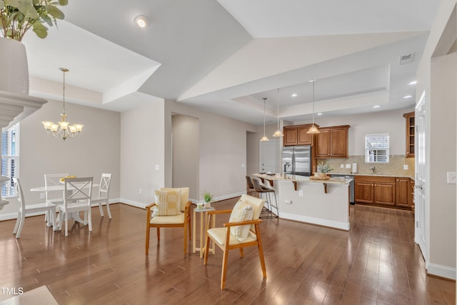 936 Blue Bird Ln, Wake Forest, NC 27587 - kitchen with appliances with stainless steel finishes, a tray ceiling, brown cabinets, dark wood-type flooring, and decorative backsplash
