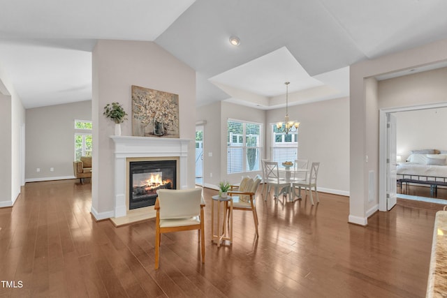 936 Blue Bird Ln, Wake Forest, NC 27587 - dining space with a glass covered fireplace, wood finished floors, a chandelier, and vaulted ceiling