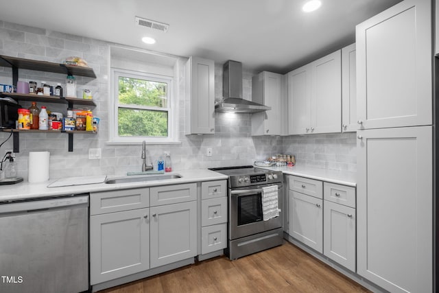 1319 Legend Rd, Raleigh, NC 27603 - kitchen featuring stainless steel appliances, wall chimney exhaust hood, light countertops, tasteful backsplash, and recessed lighting