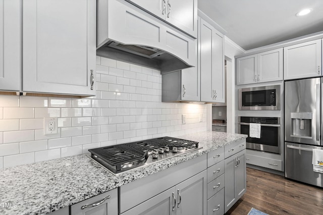1066 Bingley Dr, Durham, NC 27703 - kitchen with appliances with stainless steel finishes, premium range hood, light stone counters, backsplash, and dark wood-style flooring