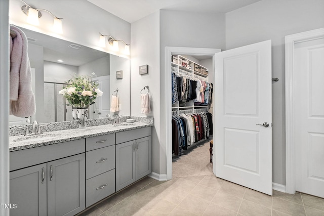 1066 Bingley Dr, Durham, NC 27703 - bathroom with double vanity, a shower stall, tile patterned flooring, and a walk in closet