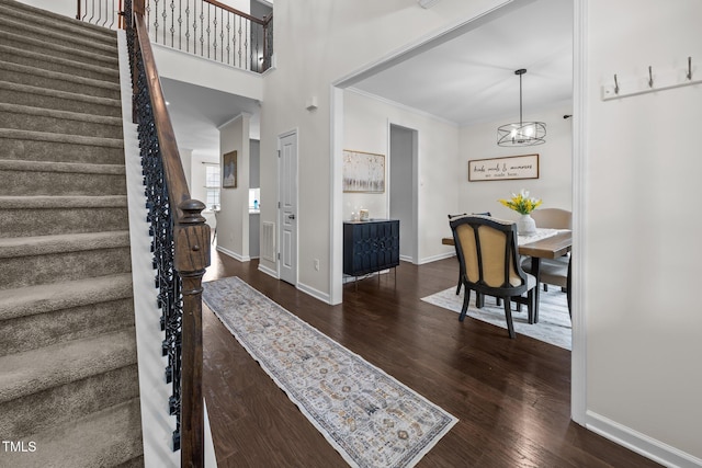 1304 Bromby Ave, Knightdale, NC 27545 - entryway with stairs, wood finished floors, a chandelier, and crown molding