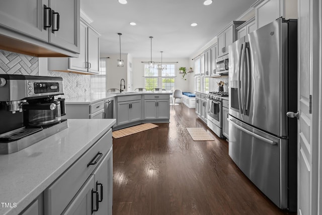 1304 Bromby Ave, Knightdale, NC 27545 - kitchen with appliances with stainless steel finishes, a peninsula, recessed lighting, dark wood-type flooring, and backsplash