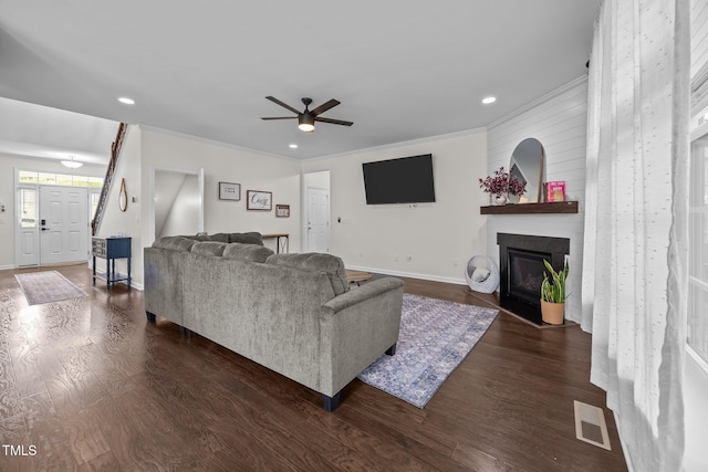 1304 Bromby Ave, Knightdale, NC 27545 - living room featuring ceiling fan, a fireplace, dark wood-style flooring, ornamental molding, and recessed lighting