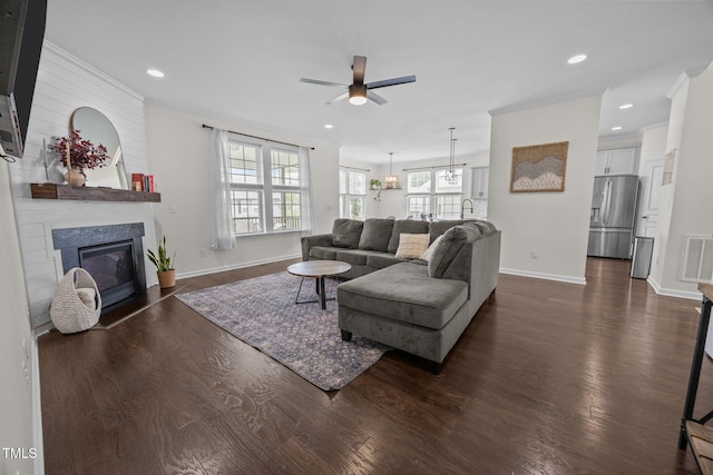 1304 Bromby Ave, Knightdale, NC 27545 - living room featuring ceiling fan, dark wood-type flooring, a fireplace, crown molding, and recessed lighting