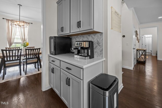 1304 Bromby Ave, Knightdale, NC 27545 - kitchen with crown molding, a chandelier, light countertops, gray cabinets, and dark wood-style floors