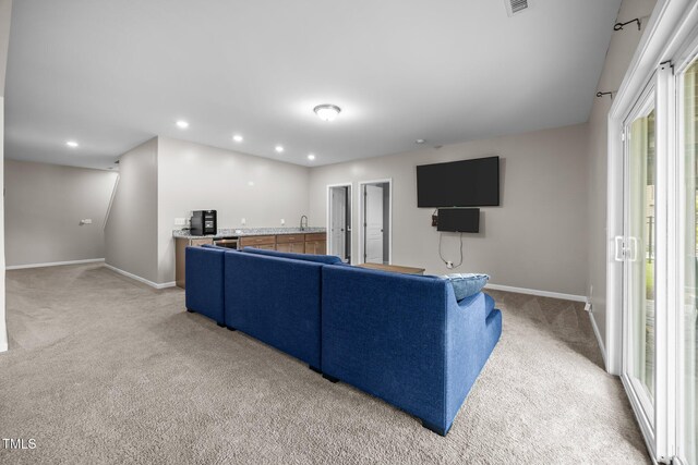 1304 Bromby Ave, Knightdale, NC 27545 - living area with light colored carpet, recessed lighting, and bar with sink
