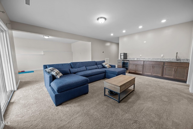 1304 Bromby Ave, Knightdale, NC 27545 - living room featuring wine cooler, light colored carpet, bar with sink, and recessed lighting
