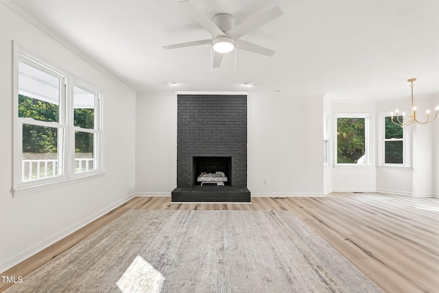 104 S Nikol Way, Clayton, NC 27520 - unfurnished living room featuring wood finished floors, crown molding, a brick fireplace, a chandelier, and ceiling fan