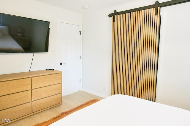 1523 Ivy Ln, Raleigh, NC 27609 - bedroom featuring light wood-type flooring and a barn door