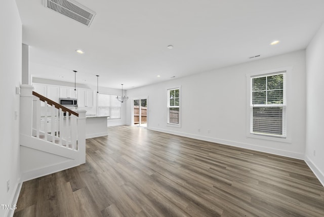 1254 Camden Ave, Durham, NC 27701 - unfurnished living room featuring plenty of natural light, recessed lighting, wood finished floors, and a chandelier
