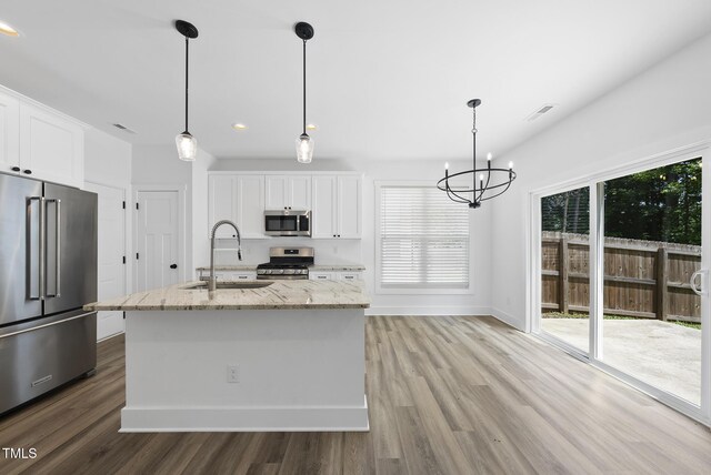 1254 Camden Ave, Durham, NC 27701 - kitchen featuring stainless steel appliances, wood finished floors, light stone counters, white cabinetry, and recessed lighting