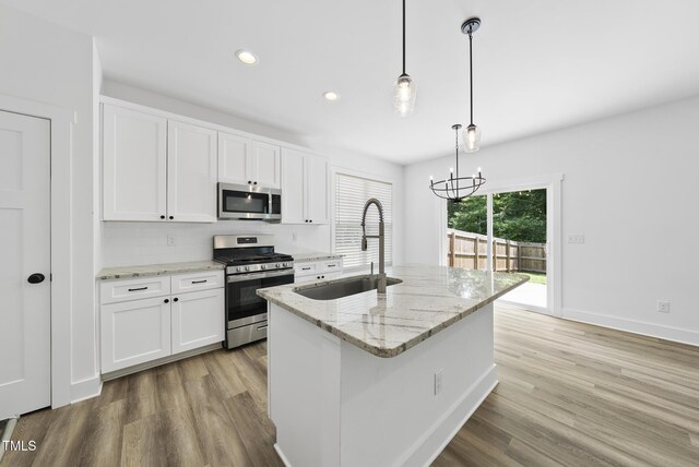 1254 Camden Ave, Durham, NC 27701 - kitchen with appliances with stainless steel finishes, a chandelier, white cabinetry, wood finished floors, and recessed lighting