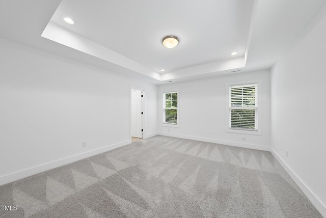1254 Camden Ave, Durham, NC 27701 - spare room featuring a tray ceiling, recessed lighting, and light colored carpet