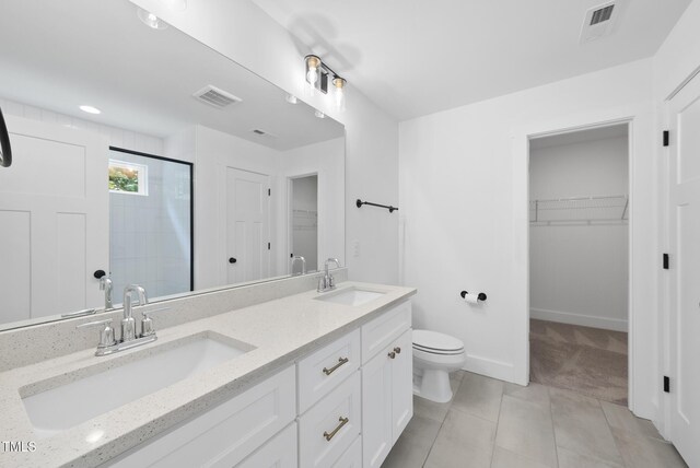1254 Camden Ave, Durham, NC 27701 - full bath with a stall shower, a walk in closet, tile patterned floors, and double vanity