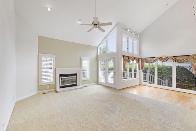 2944 Ballybunion Way, Raleigh, NC 27613 - unfurnished living room with high vaulted ceiling, a ceiling fan, carpet floors, and a glass covered fireplace