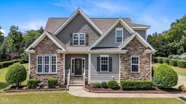 1012 Tavernier Knoll Ln, Raleigh, NC 27603 - view of front of property featuring stone siding, a front yard, and a shingled roof