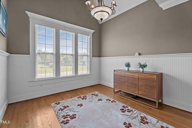 1012 Tavernier Knoll Ln, Raleigh, NC 27603 - sitting room with plenty of natural light, a wainscoted wall, wood finished floors, and a chandelier