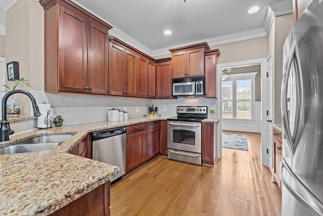 1012 Tavernier Knoll Ln, Raleigh, NC 27603 - kitchen with stainless steel appliances, crown molding, light wood-type flooring, light stone counters, and tasteful backsplash