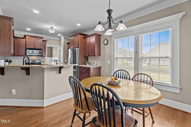 1012 Tavernier Knoll Ln, Raleigh, NC 27603 - dining area featuring crown molding, light wood-style floors, recessed lighting, and a chandelier