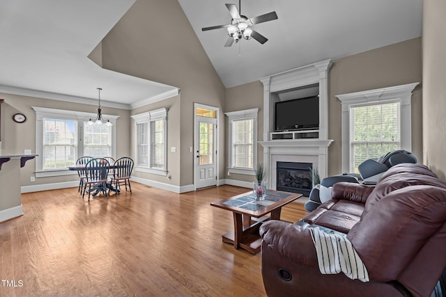 1012 Tavernier Knoll Ln, Raleigh, NC 27603 - living area with a chandelier, ceiling fan, a fireplace, light wood finished floors, and high vaulted ceiling