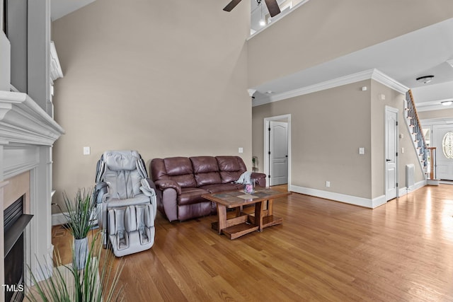 1012 Tavernier Knoll Ln, Raleigh, NC 27603 - living area with light wood finished floors, ornamental molding, ceiling fan, and a fireplace