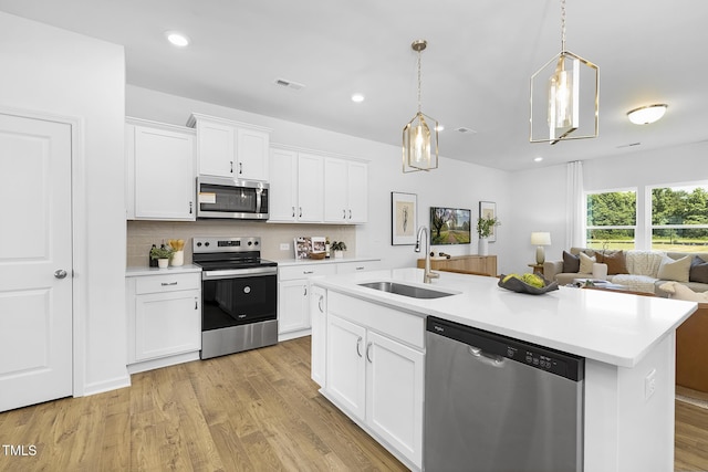 34 Mable Ct Unit 22, Lillington, NC 27546 - kitchen featuring appliances with stainless steel finishes, light countertops, white cabinets, an island with sink, and recessed lighting