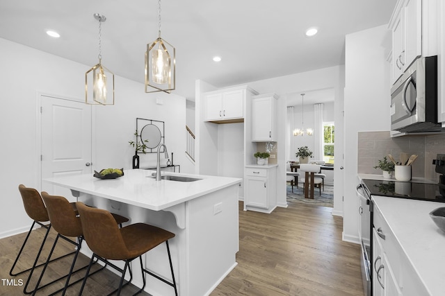 34 Mable Ct Unit 22, Lillington, NC 27546 - kitchen featuring stainless steel appliances, white cabinetry, a breakfast bar, light countertops, and wood finished floors