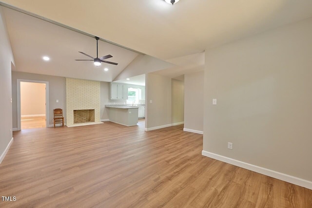 369 Historic Village Dr, Roxboro, NC 27574 - unfurnished living room with a ceiling fan, light wood-type flooring, vaulted ceiling, recessed lighting, and a brick fireplace