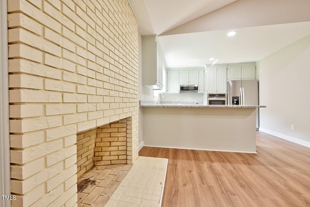 369 Historic Village Dr, Roxboro, NC 27574 - kitchen with stainless steel appliances, light wood-style flooring, a peninsula, lofted ceiling, and light stone counters
