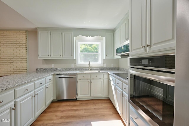 369 Historic Village Dr, Roxboro, NC 27574 - kitchen with stainless steel appliances, light wood-type flooring, white cabinets, and light stone countertops