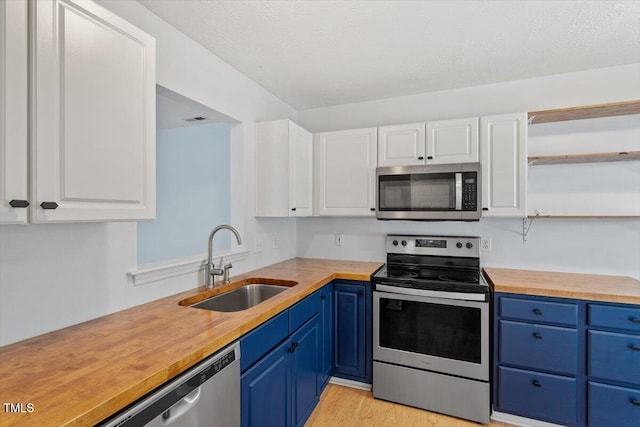 2733 Midway Park Ct, Raleigh, NC 27610 - kitchen featuring appliances with stainless steel finishes, blue cabinetry, and white cabinetry