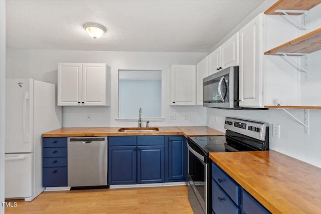 2733 Midway Park Ct, Raleigh, NC 27610 - kitchen featuring stainless steel appliances, wood counters, blue cabinetry, white cabinetry, and a textured ceiling