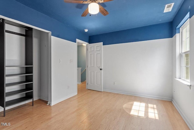 2733 Midway Park Ct, Raleigh, NC 27610 - unfurnished bedroom with wood finished floors, multiple windows, and a ceiling fan