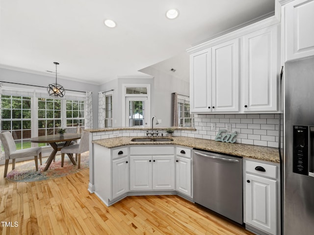 20 Little River Ct, Youngsville, NC 27596 - kitchen featuring appliances with stainless steel finishes, a peninsula, ornamental molding, white cabinets, and light wood finished floors