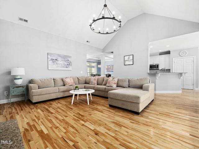 20 Little River Ct, Youngsville, NC 27596 - living area featuring light wood-type flooring, a chandelier, and high vaulted ceiling