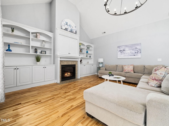20 Little River Ct, Youngsville, NC 27596 - living room with light wood finished floors, a chandelier, high vaulted ceiling, and a fireplace with flush hearth